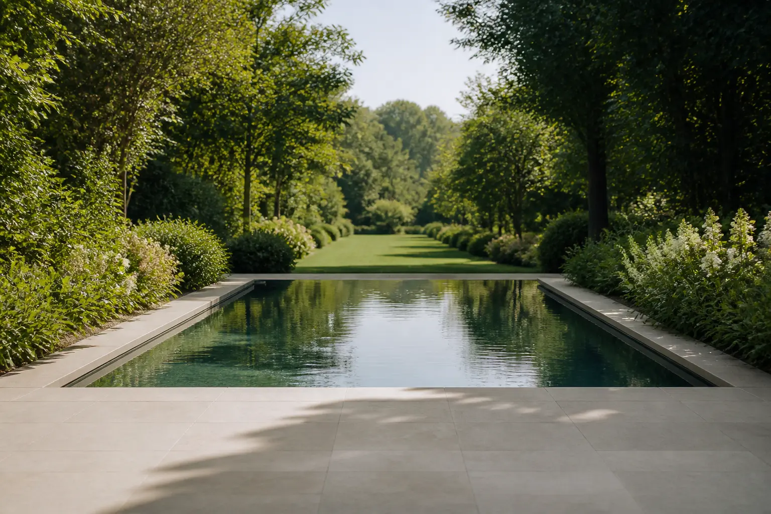 Piscine dans le jardin alignée sur l’axe de vue, prolongeant la perspective depuis la terrasse.
